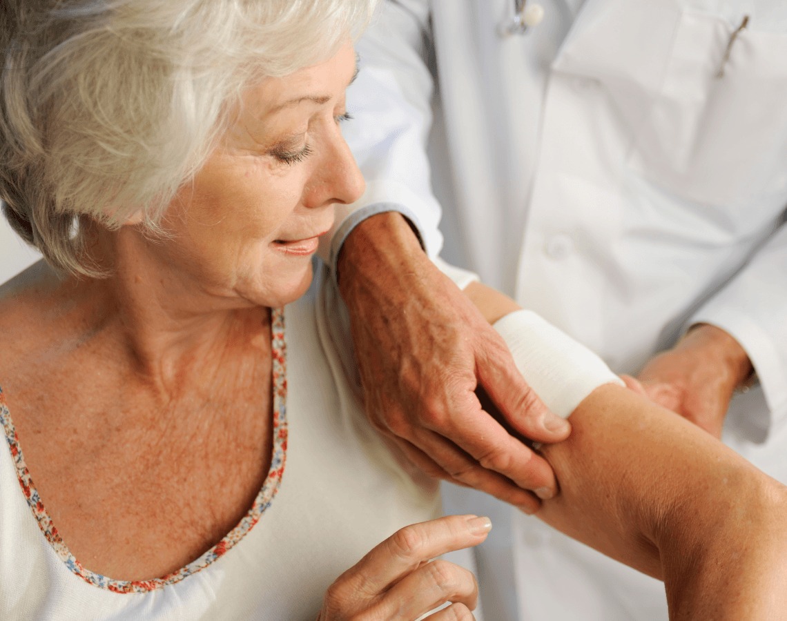 Woman receiving help getting her wound covered on her arm